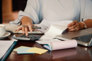 A CPA uses a laptop and calculator for tax calculations, showcasing essential tax planning skills.