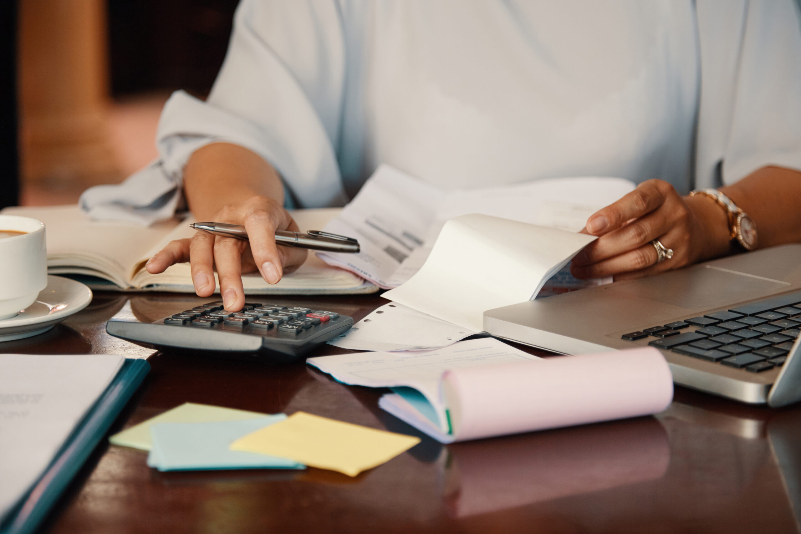 A CPA uses a laptop and calculator for tax calculations, showcasing essential tax planning skills.