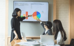 A group of young professionals meeting in a conference room discusiing three D's